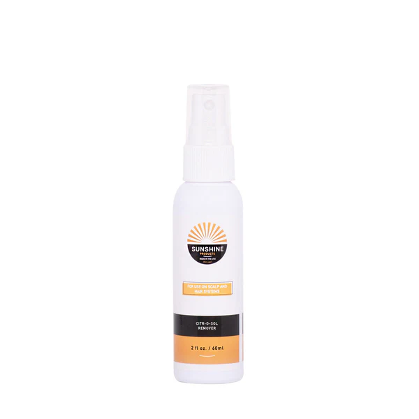 A spray bottle of sunscreen on top of a white surface.