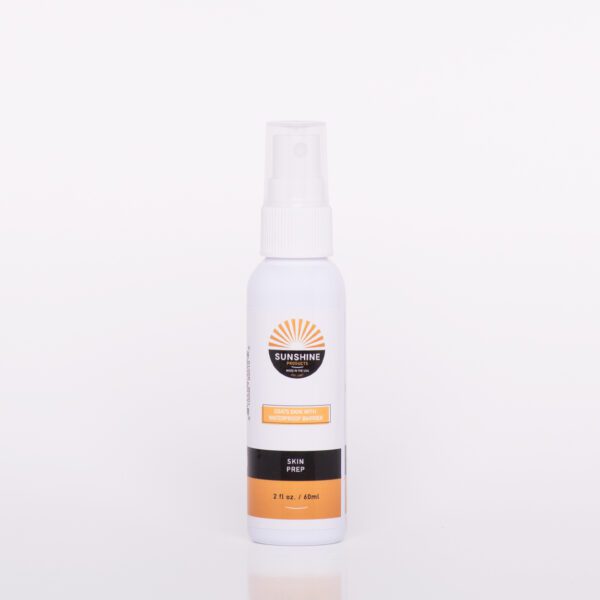 A spray bottle of lotion on top of a white table.