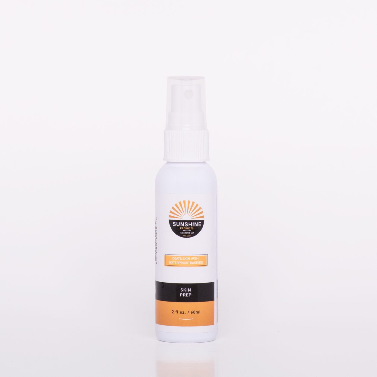 A spray bottle of lotion on top of a white table.